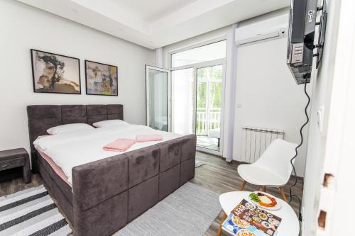 a bedroom with a large bed and a tv at Modern Apartment in the Heart of the City Center! in Sarajevo
