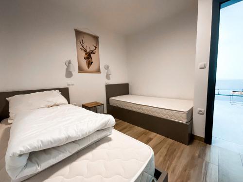 1 dormitorio con 2 camas y ventana en Sunshine Apartments Golte COMFORT en Mozirje