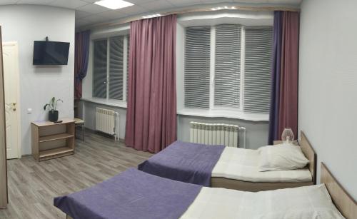 a hospital room with two beds and a tv at Гостиница На Набережной in Kotlas