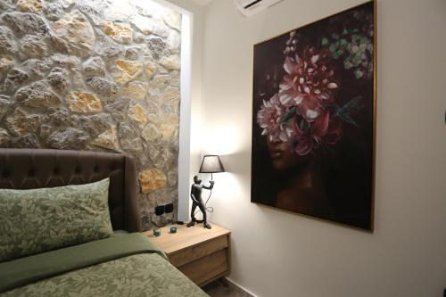 a bedroom with a bed and a painting on the wall at LA Larissa Luxury Apartments Kreousa in Larisa