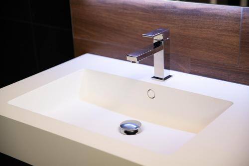 a white bathroom sink with a silver faucet at Arca Guest House in San Trovaso