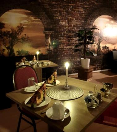 una mesa con dos rebanadas de pizza y una vela en ella en Pension Parkblick, en Braunlage