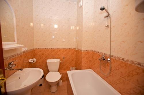 a bathroom with a toilet and a shower and a sink at Семеен Хотел Елена Палас in Nesebar