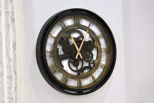 a black and gold clock on a wall at LA Larissa Luxury Apartments Kreousa in Larisa