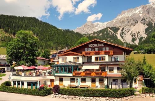 un hotel en las montañas con montañas en el fondo en Hotel-Appartement Hochkönig en Ramsau am Dachstein