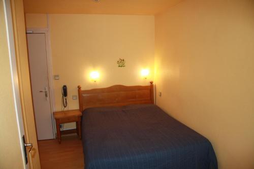a small bedroom with a bed and a telephone at gîte le Dauphin in Saint-Pierre-des-Nids