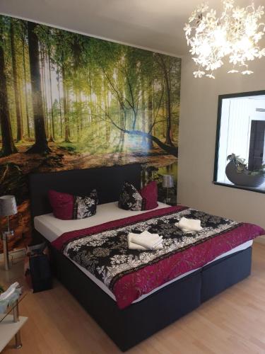 a bedroom with a large bed with a painting on the wall at Pension Parkblick in Braunlage