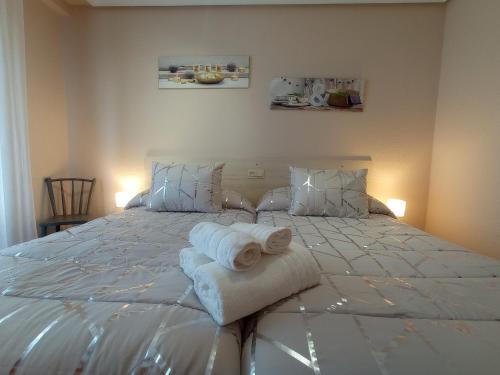 a bedroom with a large white bed with towels on it at Pedroenea Apartamento Elizondo in Elizondo