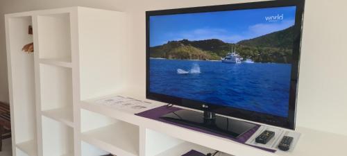 a flat screen tv sitting on a white shelf at Pousada Caminho da Praia in Jericoacoara