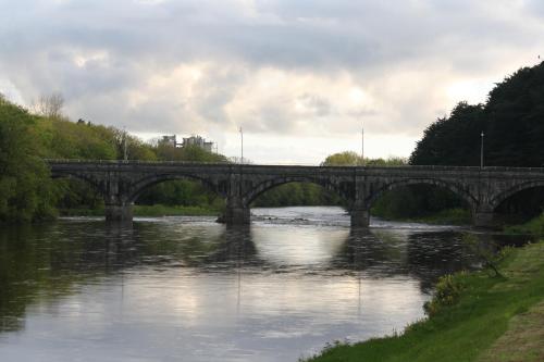 a stone bridge over a river with a river at Palmgrove Bed & Breakfast in Listowel