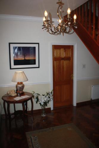 a living room with a table and a chandelier at Palmgrove Bed & Breakfast in Listowel