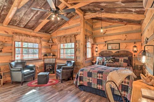 Blockhausschlafzimmer mit einem Bett und 2 Stühlen in der Unterkunft Hand-Crafted Creekside Treehouse with Grill! in Cosby