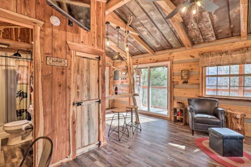 ein Wohnzimmer mit Holzwänden und einer Decke mit Holzböden in der Unterkunft Hand-Crafted Creekside Treehouse with Grill! in Cosby