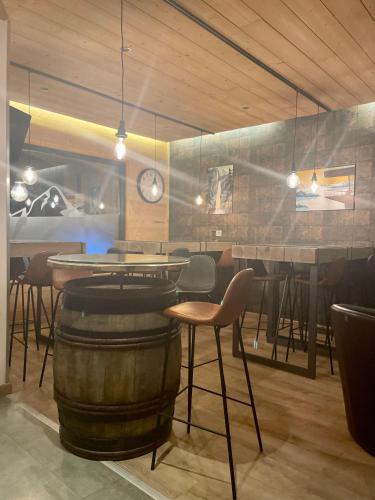 a restaurant with a table and chairs and a barrel at Hotel L'Edelweiss in Pralognan-la-Vanoise