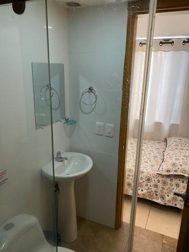 a bathroom with a sink and a shower with a toilet at Luxury Hostal in Manizales