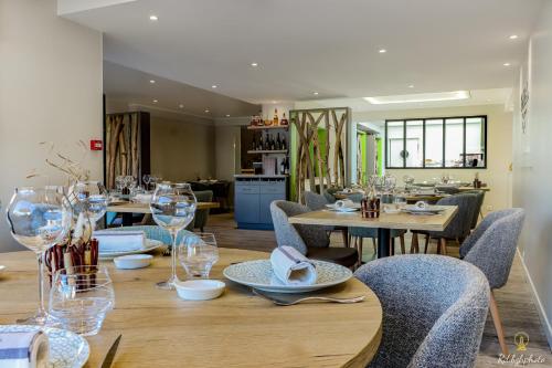 une salle à manger avec des tables en bois, des chaises et des verres dans l'établissement Logis Hôtel du Parc, à Perros-Guirec