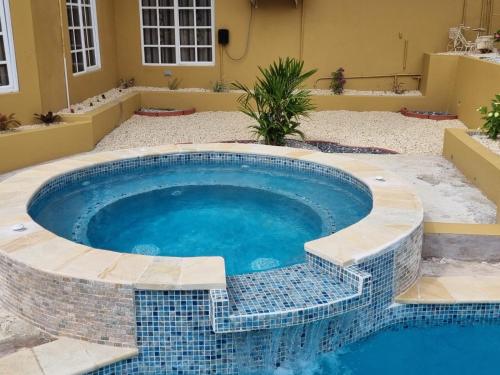 una piscina en un patio trasero con una piscina de mosaico en Paradise Place Apartments en Mount Irvine