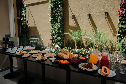 波薩達斯的住宿－Hotel Batista，餐桌上摆放着食物和饮料
