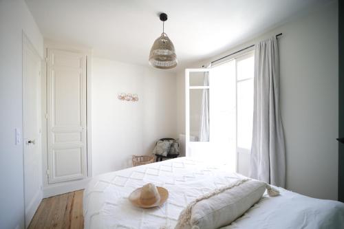 Villa Jeanne - Confort et plage في لو تريبور: غرفة نوم مع سرير مع قبعة عليه
