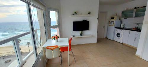 a kitchen with a table and a view of the ocean at Hotel Apartment TLV-bat yam 81 in Bat Yam