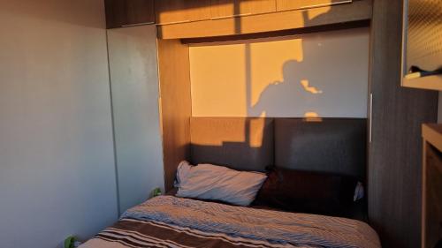 a bedroom with a window with a shadow of a man at Résidence Château Leenhardt - Appartement T2 Face à la Mer in Le Grau-du-Roi