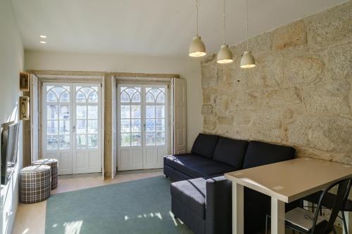 a living room with a couch and a stone wall at N Apartments - Chã in Porto