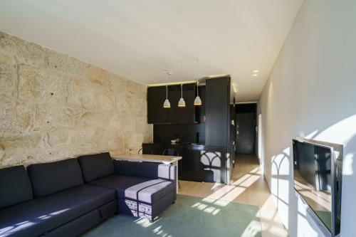 a living room with a couch and a kitchen at N Apartments - Chã in Porto