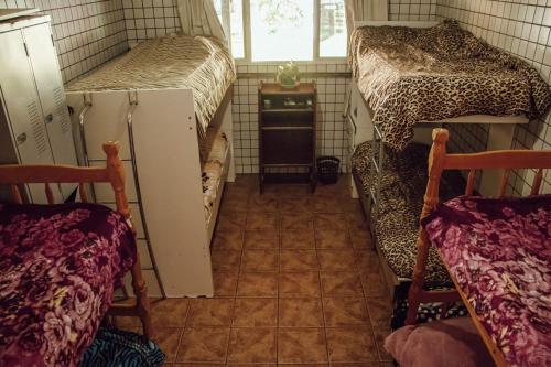 a room with two bunk beds and a tiled floor at HOSTEL BARRA BAR in Balneário Camboriú