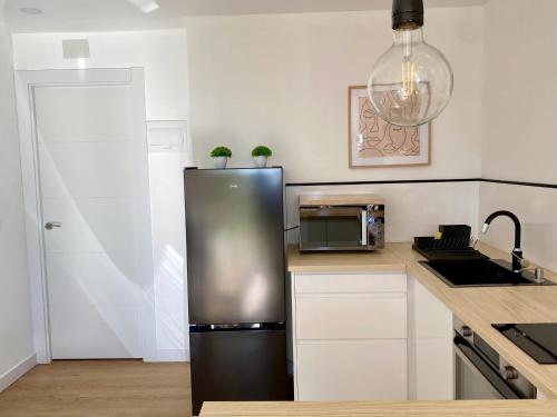 a kitchen with a stainless steel refrigerator and a microwave at Suite Breeze - Private Heated Pool in Málaga