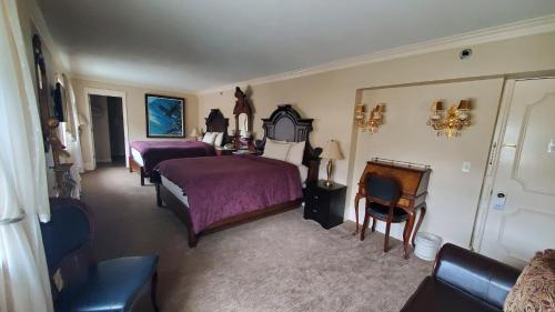 a bedroom with two beds and a table and chairs at Lowell Inn in Stillwater