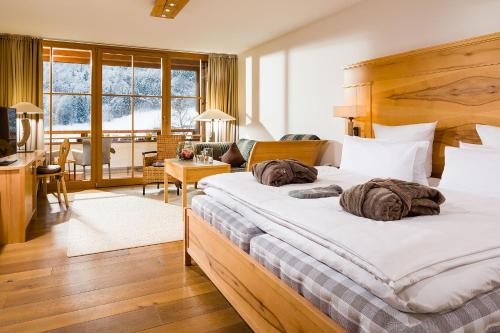 a bedroom with a large bed and a living room at Berghotel Rehlegg in Ramsau