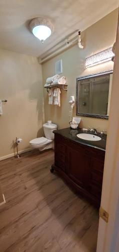 a bathroom with a sink and a toilet and a mirror at Lowell Inn in Stillwater
