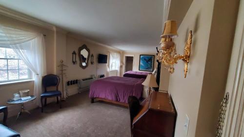 a bedroom with a bed and a table and a mirror at Lowell Inn in Stillwater