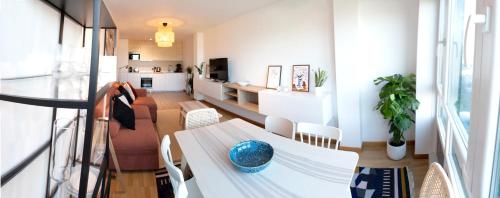 a living room with a table and a dining room at Apartamento Paseo Marítimo Laxe in Laxe