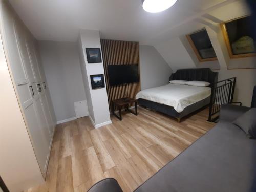 ein kleines Schlafzimmer mit Bett und Holzboden in der Unterkunft Mieszkanie 2 pokojowe - 5km od SKI SUN Świeradów Zdrój in Pobiedna