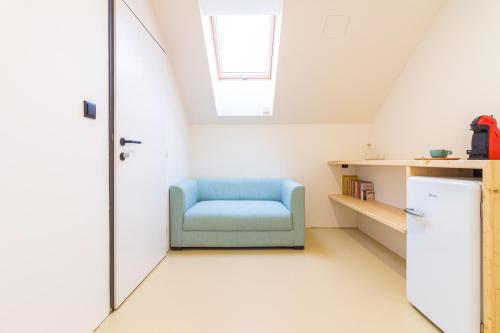 a room with a blue chair and a refrigerator at Coffein apartments in Mostkovice
