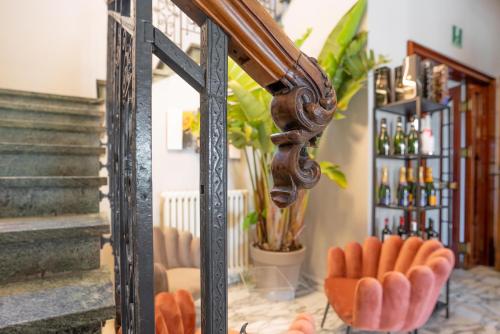 a mirror with orange chairs in a room with stairs at The Rif - Boutique Hotel in Pisa