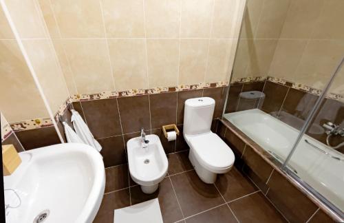 łazienka z umywalką, toaletą i wanną w obiekcie Apartamento Paseo Marítimo Laxe w mieście Laxe
