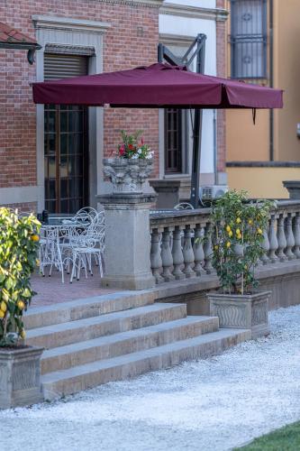 a porch with a table and chairs and an umbrella at The Rif - Boutique Hotel in Pisa