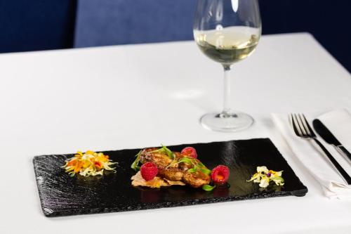 a plate of food on a table with a glass of wine at Hotel Cristal Porto in Porto