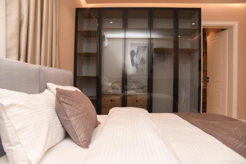a bedroom with a white bed and a glass cabinet at J&D Rooms Korce in Korçë