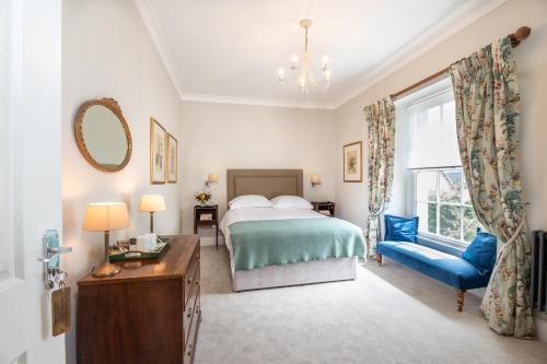 a bedroom with a bed and a blue chair at Baskerville House in Clyro