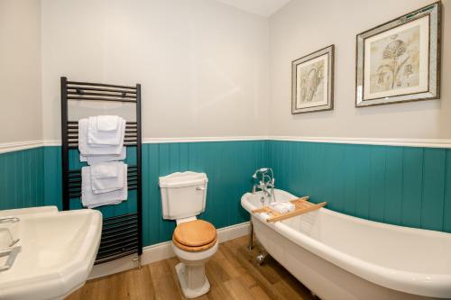 a bathroom with a tub and a toilet and a sink at Baskerville House in Clyro