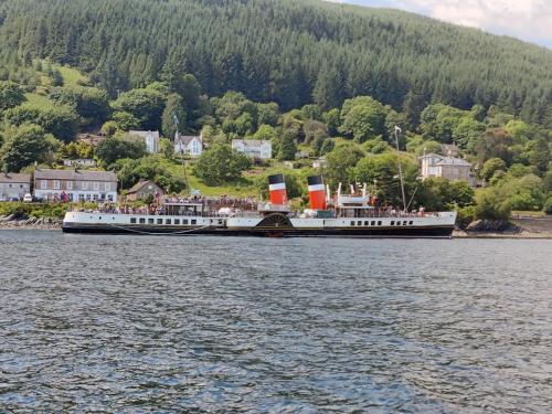 a large boat in the water with people on it at Douglas Park Guest House in Dunoon