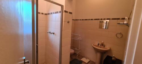 een badkamer met een douche, een toilet en een wastafel bij Hornbill Helipad 1 in Centurion