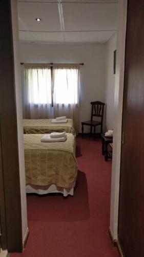 a hotel room with a bed and a window at Kalken Hotel by MH in El Calafate