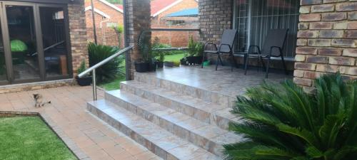 a patio with a set of stairs next to a house at Hornbill Helipad 1 in Centurion