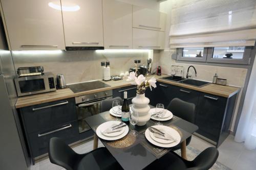 ラリサにあるLA Larissa Luxury Apartments Koronisのキッチンにテーブルと椅子がある