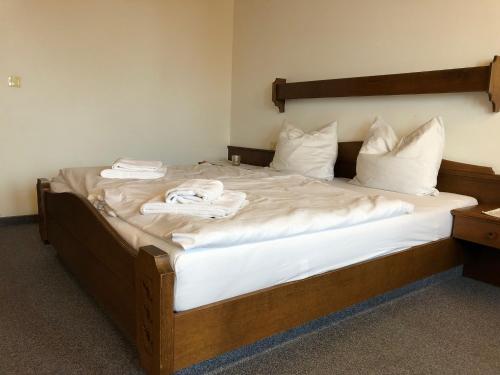 a large bed with white sheets and pillows on it at Sportpension Therese in Westendorf