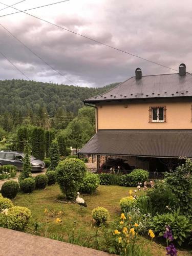 a house with a yard with flowers in front of it at Cottage "Lure" in Yaremche